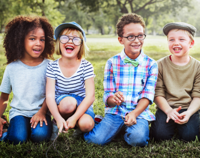 group of children sitting on the grass laughing